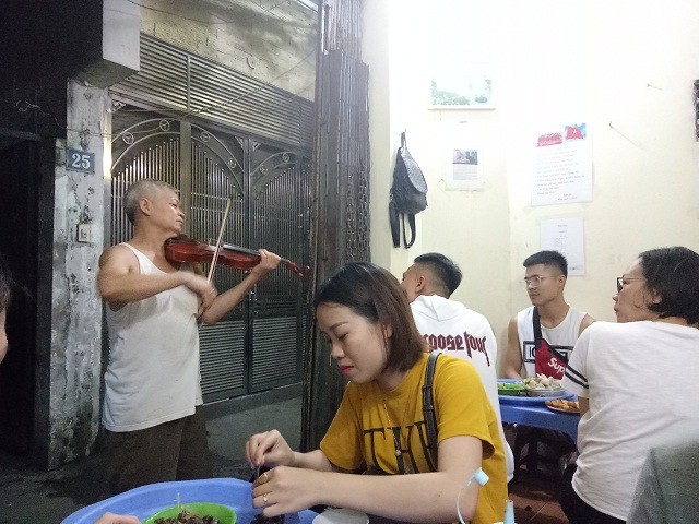 Quán ốc 24 năm “vừa bán vừa đuổi khách” vẫn kín chỗ nhờ chiêu độc của ông chủ quán - 1 Vừa ăn ốc vừa nghe đàn là điểm độc đáo chỉ có ở quán ốc của ông Sỹ.