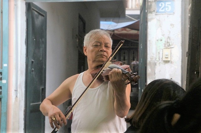 Quán ốc 24 năm “vừa bán vừa đuổi khách” vẫn kín chỗ nhờ chiêu độc của ông chủ quán - 2 Ông Sỹ nâng niu cây đàn như tài sản quý của đời mình.
