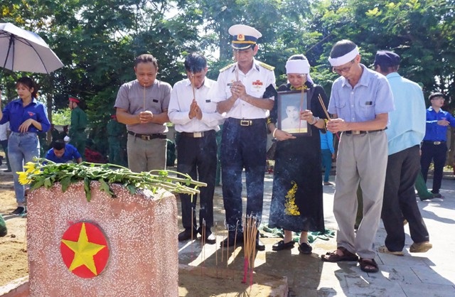 An táng 98 hài cốt liệt sĩ hi sinh ở nước bạn Lào - 10 Thân nhân liệt sĩ Nguyễn Đình Quảng (quê Ninh Bình) trước phần mộ. Liệt sĩ Nguyễn Đình Quảng là trường hợp duy nhất xác định được danh tính, quê quán trong số 98 hài cốt liệt sĩ được quy tập về nước trong đợt này