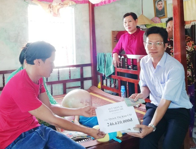 Hơn 246 triệu đồng đến với bé 3 tuổi đầu to dần như bong bóng - 2 PV Dân trí đang trao tiền bạn đọc hỗ trợ cho gia đình chị Quách Thị Kim Chi.