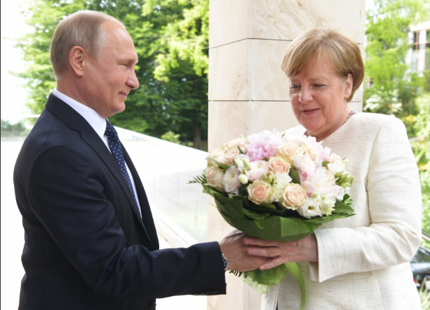 Bó hoa gây tranh cãi của Tổng thống Putin tặng Thủ tướng Đức - 1 Tổng thống Putin tặng hoa cho Thủ tướng Merkel hôm 18/5 (Ảnh: RT)