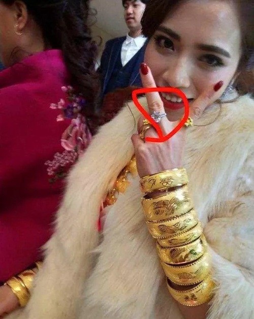Đám cưới ngập vàng ở Trung Quốc gây xôn xao dư luận - 4 Trong đám cưới, cô dâu đeo trên người cả cân vàng, trên tay là chiếc nhẫn cưới đính kim cương trị giá vài tỷ.