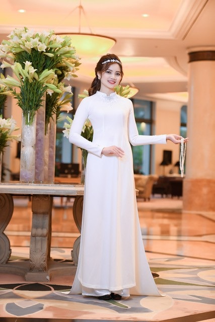 Áo dài Mẹ Âu Cơ bất ngờ mở màn Áo dài Festival tại Mỹ - 6 Đây là thiết kế màu trắng tinh khiết, trên đó được đính kết hoa văn, hoạ tiết từ kim cương và đá quý màu trắng, kết hợp cùng trang sức ngọc trai.