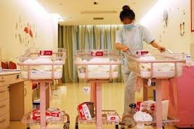 Bà mẹ trẻ bỏ 250 triệu đồng/tháng để ở cữ “sang chảnh” - 2 Một nhân viên của trung tâm ở cữ đang chăm sóc những bé sơ sinh. (Nguồn: AFP)