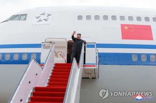 "Ông Kim Jong-un mượn máy bay của Thủ tướng Trung Quốc tới Singapore" - 1 Bức ảnh do Rodong Sinmun công bố cho thấy ông Kim Jong-un đi máy bay của Air China với quốc kỳ Trung Quốc in trên thân máy bay (Ảnh: Yonhap)