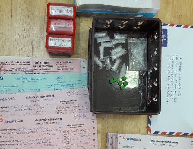 Con dấu giả, biên lai thanh toán cước phí giả cùng ma túy đá thu giữ được tại chỗ ở của hai đối tượng