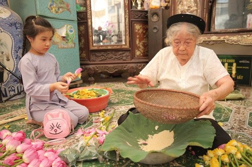 Người “gánh” trà sen qua hai thế kỷ - 1 Bà Nguyễn Thị Dần tỉ mẩn tách gạo sen để ướp trà. Ảnh: T.N