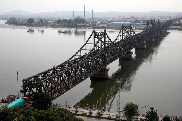 Mỹ nỗ lực chặn “cánh tay nối dài” của Triều Tiên ở nước ngoài - 2 Xe tải di chuyển qua cầu Hữu Nghị nằm ở biên giới Triều Tiên và Trung Quốc bắc qua sông Áp Lục. (Ảnh: Reuters)