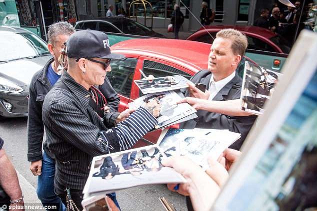 
Ngôi sao 54 tuổi được fan chào đón và xin chữ ký bên ngoài khách sạn ở Berlin, Đức.
