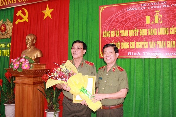 Giám đốc Công an Bình Thuận được doanh nghiệp tài trợ sang Đức học công nghệ 4.0 - 1 Thiếu tướng Nguyễn Văn Thân (bên trái) được tặng hoa trong ngày nhận quyết định tăng bậc lương cấp thiếu tướng (ảnh: Cổng thông tin điện tử tỉnh Bình Thuận)
