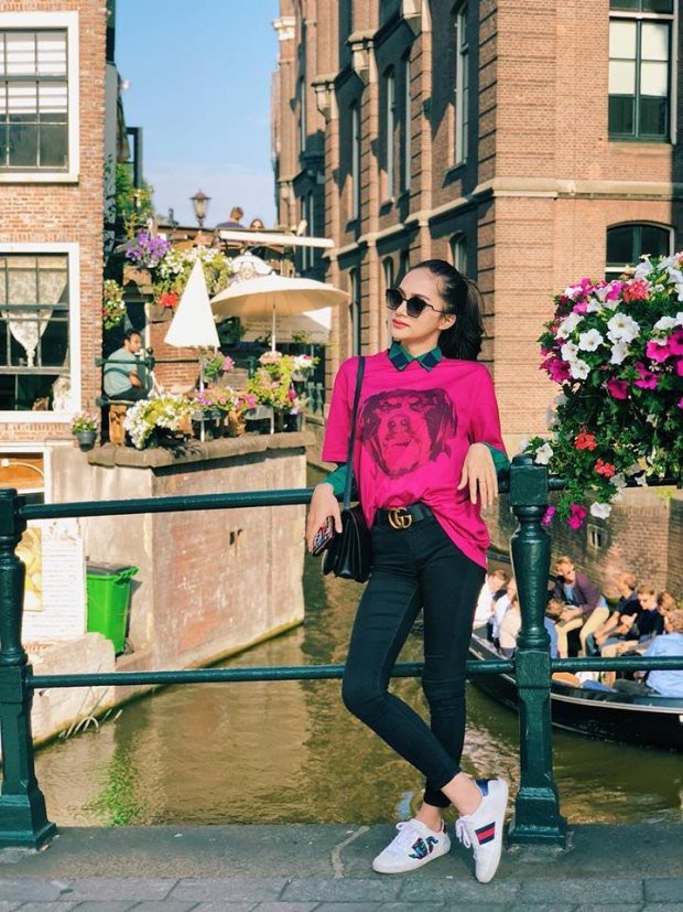 Sao Việt bất ngờ lăng-xê phong cách “kín cổng cao tường” - 3 Hoa hậu Chuyển giới Hương Giang diện áo thun dáng rộng màu hồng đậm, kết hợp cùng skinny jeans đơn giản và giày sneaker. Người đẹp cũng khéo léo sơ-vin mặt trước để lộ chiếc thắt lưng hàng hiệu.