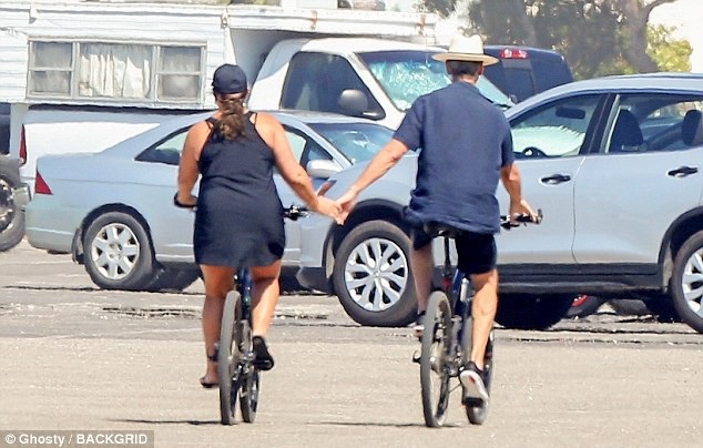 
Cặp vợ chồng vừa trò chuyện, đạp xe vừa nắm tay nhau rất hạnh phúc.
