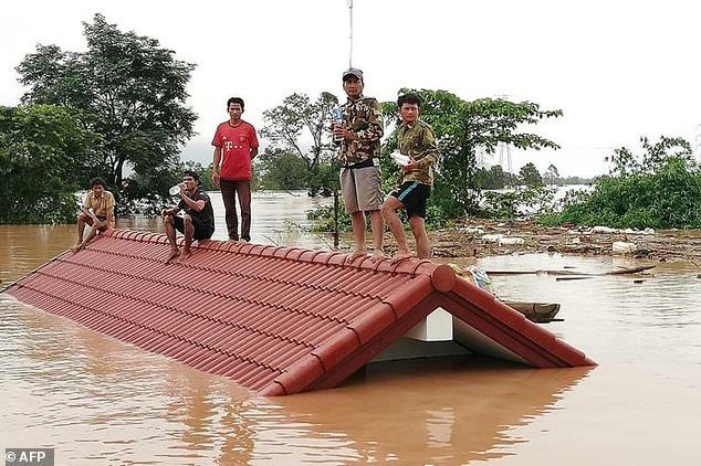 Thủ tướng Lào nói 131 người mất tích trong vụ vỡ đập thủy điện - 1
Người dân trên mái nhà chờ lực lượng cứu hộ (Ảnh: AFP)