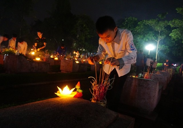 Những người vợ liệt sĩ "hóa đá" ở nghĩa trang - 5 Một em học sinh thành kính thắp nén hương tưởng nhớ, tri ân các liệt sĩ.