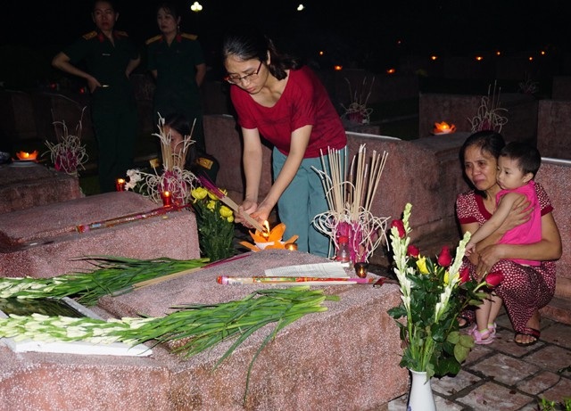 Những người vợ liệt sĩ "hóa đá" ở nghĩa trang - 3 Người phụ nữ cùng con gái và cháu tới viếng mộ của chồng tại Nghĩa trang liệt sĩ TP Vinh tối 26/7.