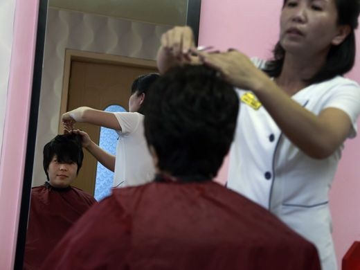 Hình ảnh mới nhất về cuộc sống của con người Triều Tiên - 1 Một phụ nữ cắt tóc tại một tiệm làm đầu ngay bên trong khuôn viên của công viên nước Munsu ở Bình Nhưỡng. Công viên nước Munsu được ví như Disneyland, nằm tại trung tâm thủ đô của Triều Tiên, đón cả du khách nước ngoài tới giải trí.
