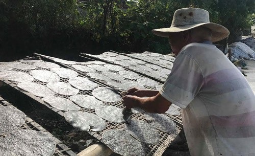 Thu lãi gần 1 triệu đồng/ngày, bánh đa Đô Lương rộng đường xuất ngoại - 1 Dưới nắng nóng hơn 40 độ C, bà con vẫn luôn tay trở đều từng chiếc bánh để bánh được khô đều. Ảnh: Mỹ Hà