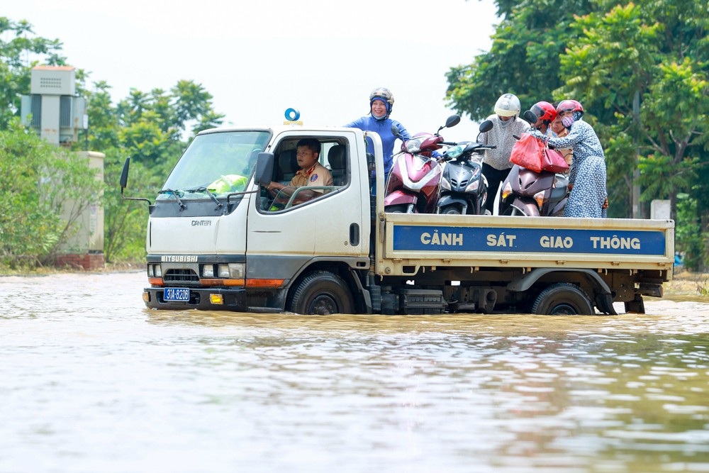 CSGT Hà Nội dùng xe tải chở người dân qua điểm ngập - 3
Người và xe người dân được vận chuyển qua đoạn ngập sâu.