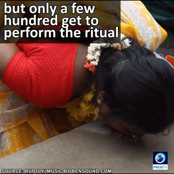 Cận cảnh một người phụ nữ quỳ gối, ăn cơm đặt trên nền đất