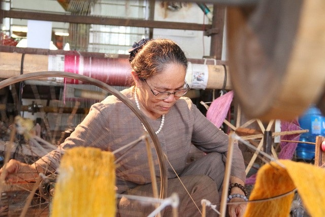 Người phụ nữ bẻ cuống sen để lấy tơ sen, một chiếc khăn quàng cổ đã có giá 4,5 triệu đồng