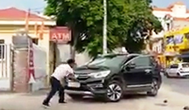 Bị đánh, người đàn ông dùng hung khí đập vào đầu xe CRV - 1 Bị đánh, ông Hồng dùng hung khí đập phá đầu xe CRV của anh Phương (ảnh cắt từ clip)