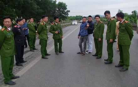 Án chung thân đối với kẻ chạy xe máy đâm tử vong Thiếu tá CSGT - 1 Hoàng Văn Trường (áo xanh) được dẫn giải đến hiện trường để phục vụ quá trình điều tra (Ảnh: Hồng Ngân).