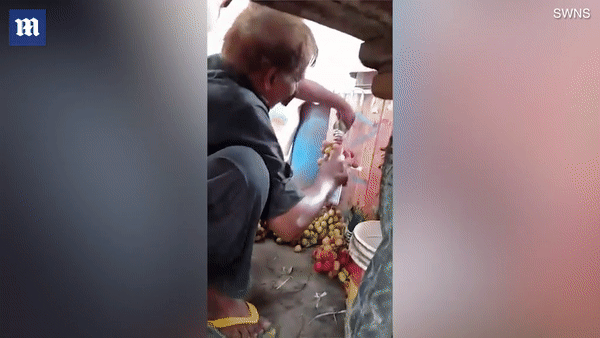Du khách “bắt quả tang” người bán hàng rong phun sơn lên nho biến xanh thành đỏ - 1 Người bán hàng rong đang phun sơn lên những chùm nho để trông bắt mắt hơn trước khi bán cho khách