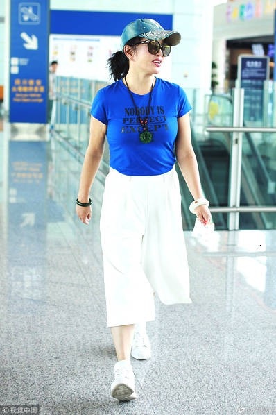 
Lưu Hiểu Khánh mặc áo phông ôm sát, quần ống rộng thời thượng và giày thể thao. Gương mặt trang điểm đậm với son đỏ sẫm.
