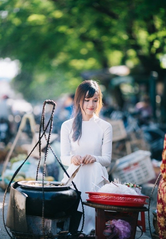 Chủ tịch tỉnh Thừa Thiên Huế vận động nữ sinh các trường đại học, THPT mặc áo dài - 8 Nữ sinh vận áo dài duyên dáng bên gánh Bún bò Huế ở chợ Đông Ba (ảnh: Nguyễn Thanh Cường)