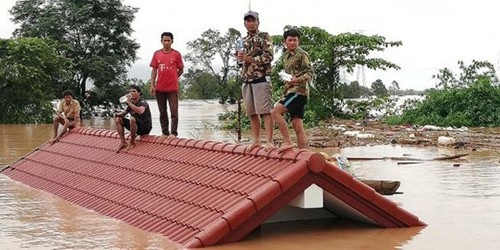 Đề nghị Lào làm rõ việc dừng xem xét đầu tư xây dựng thủy điện mới - 1 Người dân trèo lên nóc nhà chờ lực lượng cứu hộ sau khi đập thủy điện vỡ gây lũ lớn ở huyện Sanamxay, tỉnh Attapeu, đông nam Lào. Ảnh: Attapeu Today.