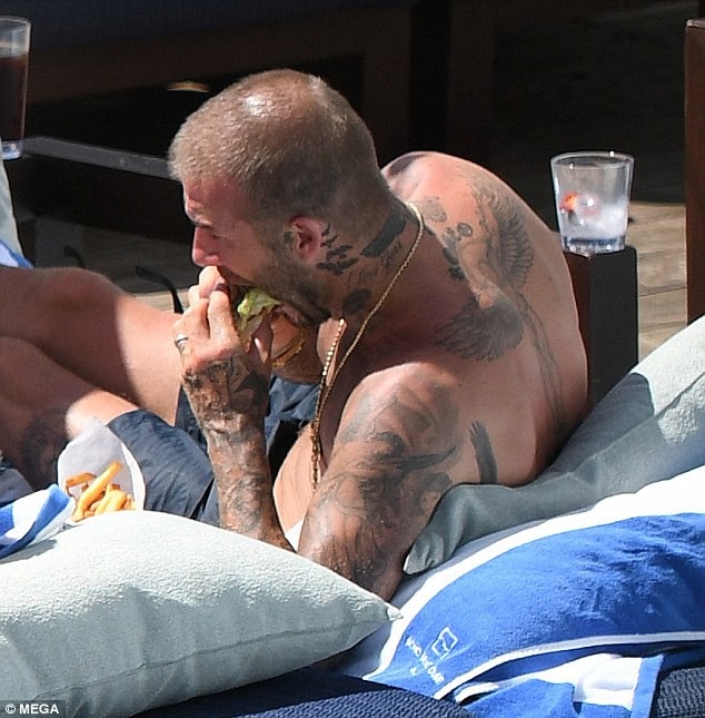 David Beckham bị rụng tóc do tuổi tác - 5
Ngôi sao 43 tranh thủ ăn nhanh sau khi bơi.