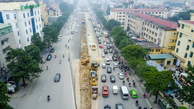 Hàng chục công nhân và nhiều máy móc đang thi công xén dải phân cách, mở rộng lòng đuờng Nguyễn Chí Thanh (Hà Nội) để giảm thiểu ùn tắc, mục tiêu sẽ hoàn thành thi công trước Tết Nguyên đán Mậu Tuất. (Ảnh: Toàn Vũ)
