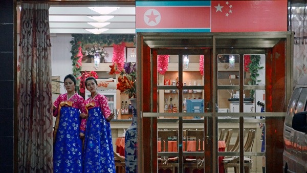 Những nữ nhân viên đứng đợi khách hàng tại cửa một nhà hàng Bắc Triều ở Trung Quốc. (Nguồn: AFP)