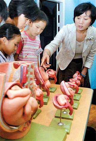 Hàn Quốc: Tranh cãi dự kiến phát bao cao su cho học sinh cấp hai - 1 Theo Diễn đàn Giáo dục Sức khỏe, việc giáo dục giới tính ở các trường cấp hai và cấp ba Hàn Quốc chỉ đạt 50%. Trong ảnh: Một nhóm học sinh tiểu học và phụ huynh học về cách bào thai lớn lên tại Trung tâm Giáo dục Giới tính Songpa ở đông Seoul.