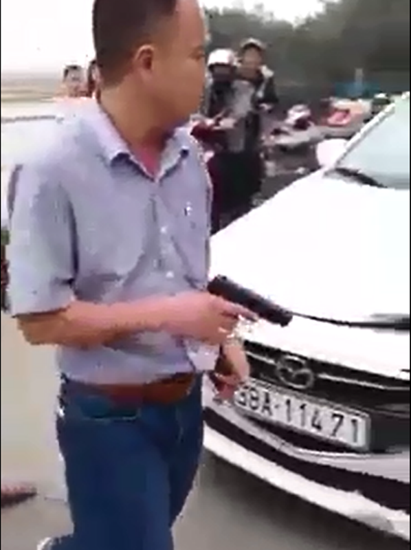 Tài xế rút súng dọa bắn người sau va chạm giao thông - 2 Người đàn ông cầm khẩu súng. Ảnh cắt từ clip