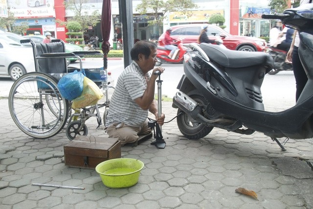 Người đàn ông cụt hai chân vẫn đi sửa xe khắp phố - Ảnh 1. Người đàn ông cụt hai chân vẫn đi sửa xe khắp phố - Ảnh 1.