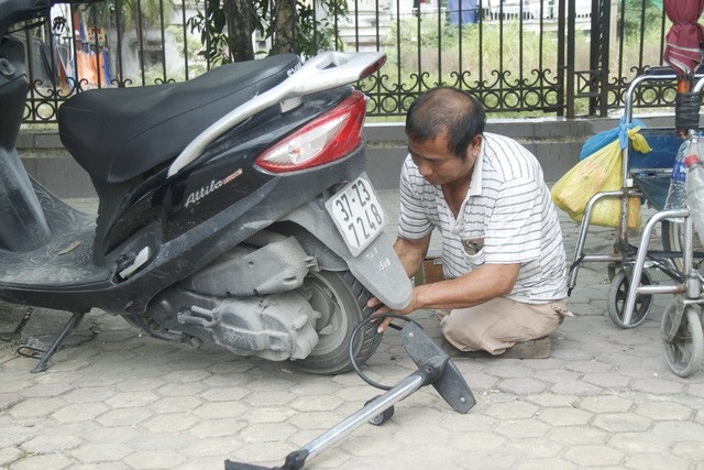 Người đàn ông cụt hai chân vẫn đi sửa xe khắp phố - Ảnh 2. Người đàn ông cụt hai chân vẫn đi sửa xe khắp phố - Ảnh 2.