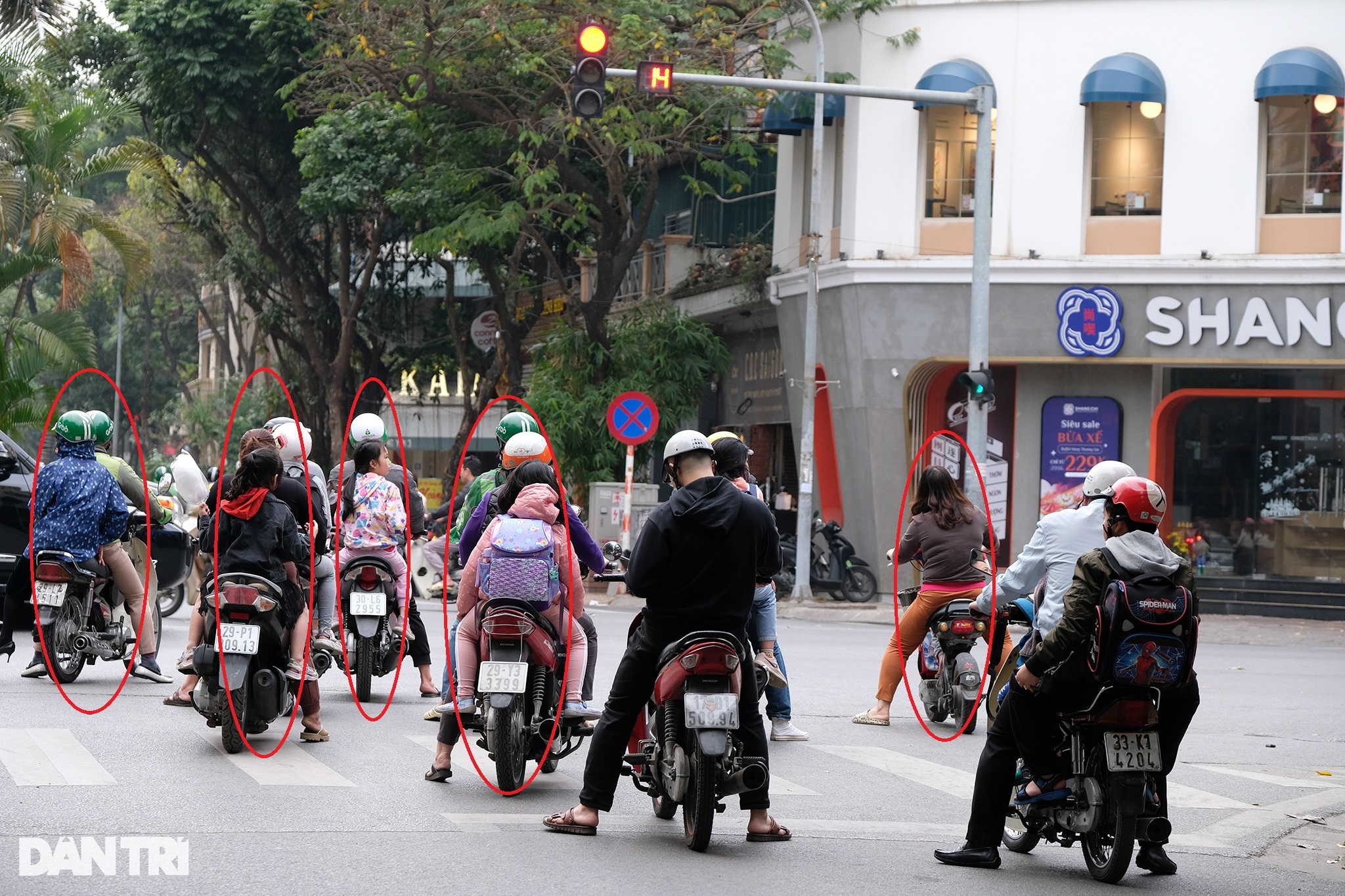 Phụ huynh đi xe máy chở trẻ nhỏ vẫn vô tư vượt đèn đỏ ở Hà Nội - 1