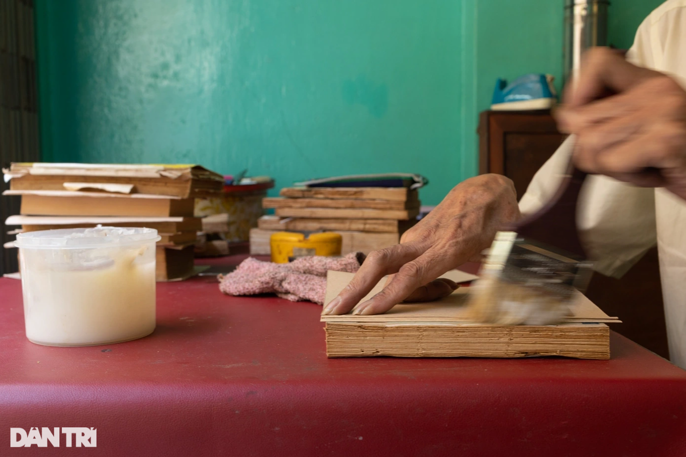 Một cuốn sách đang được ông Rạng dán keo làm bìa.
