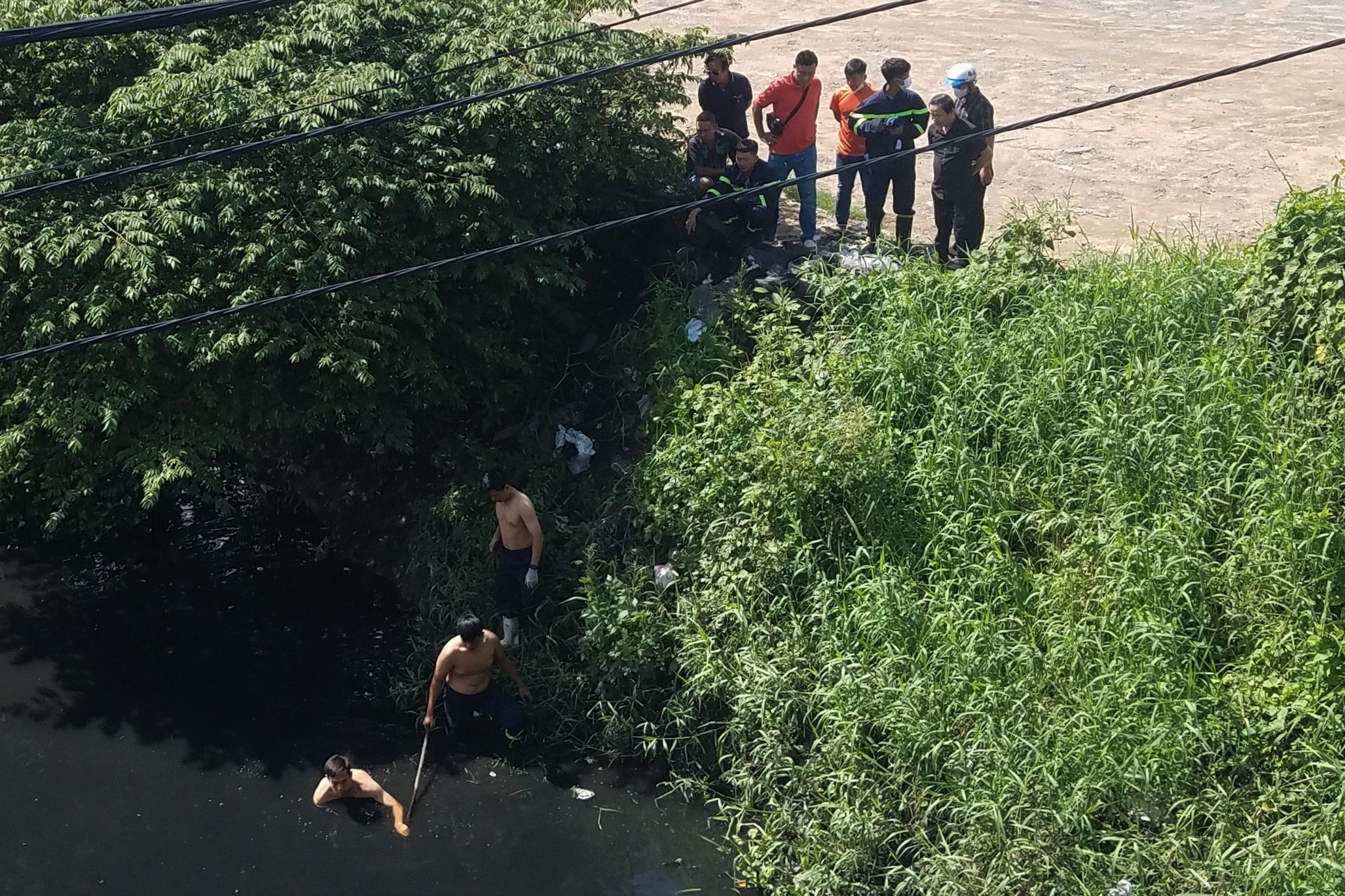 Cảnh sát lặn dưới kênh đen ngòm vì nghi có nạn nhân bị rớt xuống - 1