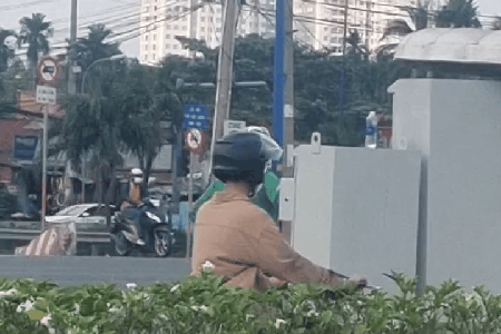 Người mặc đồ xe ôm công nghệ tác động tủ điều khiển đèn giao thông ở TPHCM