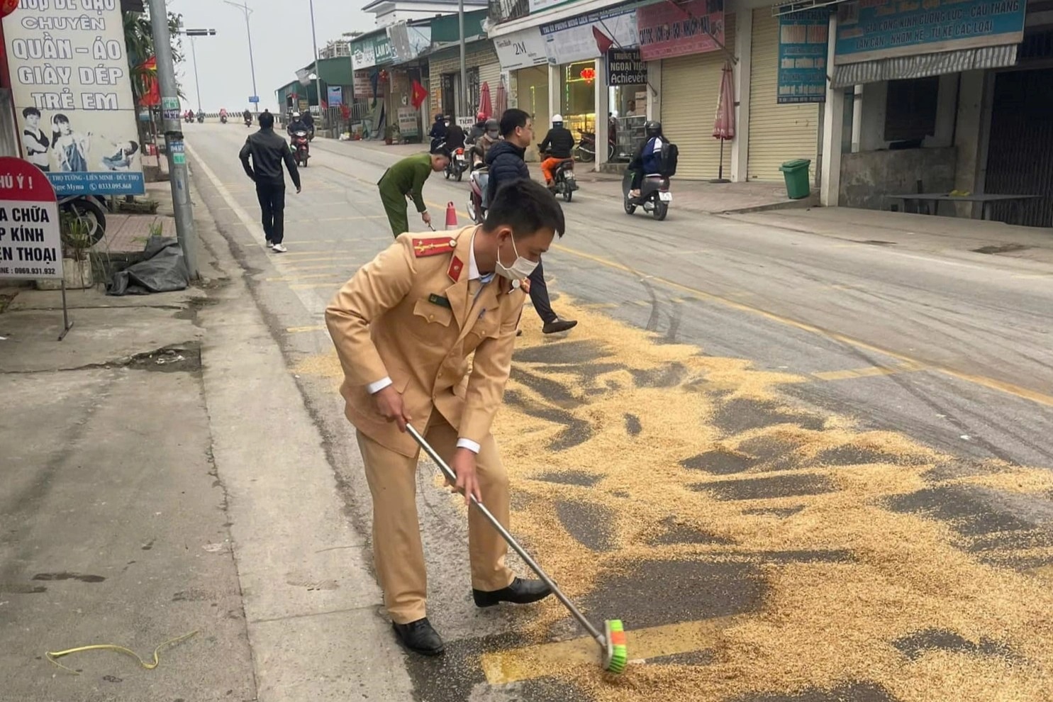 Cảnh sát xúc cát, rải vỏ trấu xử lý dầu loang trên quốc lộ