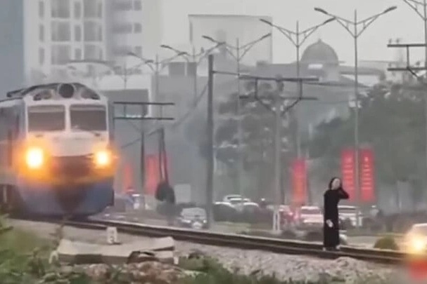 Hai phụ nữ thản nhiên "tạo dáng" trên đường ray dù tàu kéo còi liên tục