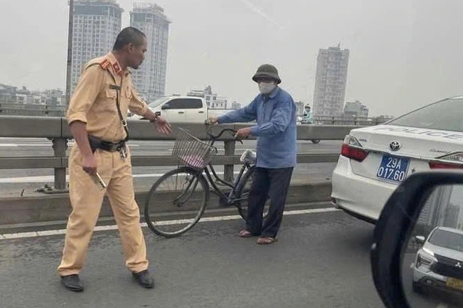 CSGT ngăn chặn cụ ông đạp xe đi ngược chiều trên cầu Nhật Tân