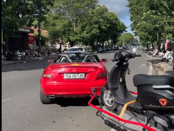 Công an làm việc với người đóng vai shipper lái ô tô mui trần kéo xe máy