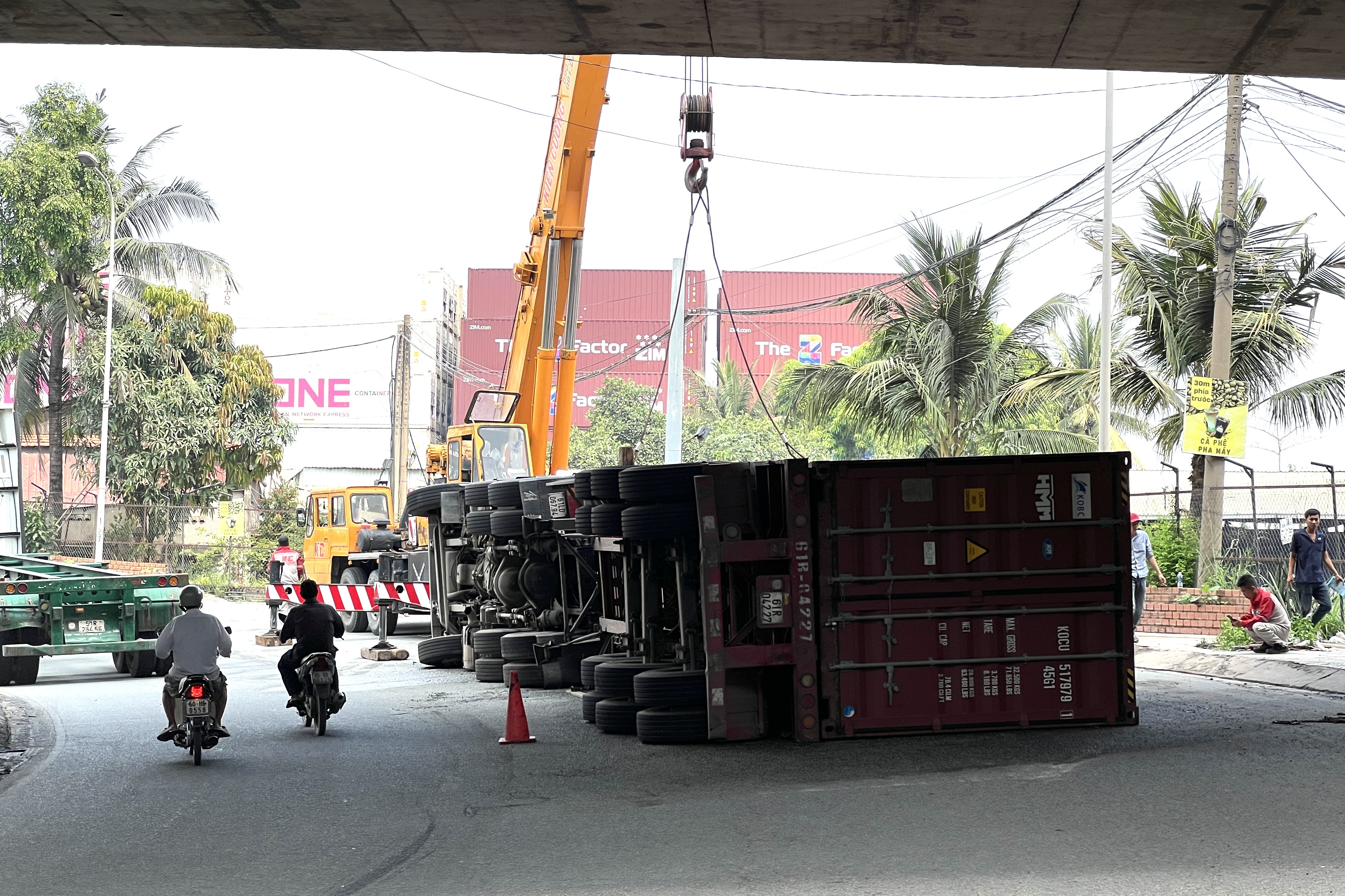 Xe đầu kéo container chở gần 30 tấn hàng lật dưới gầm cầu ở TPHCM