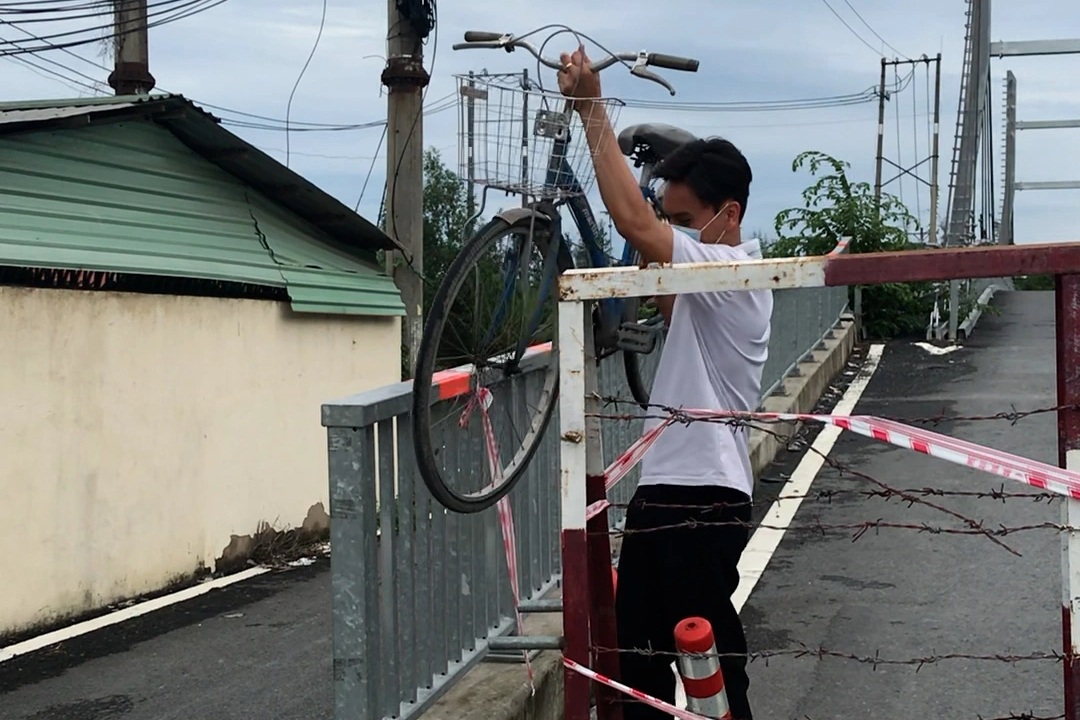 Người dân khiêng xe, đi bộ băng qua cây cầu mới khánh thành ở TPHCM