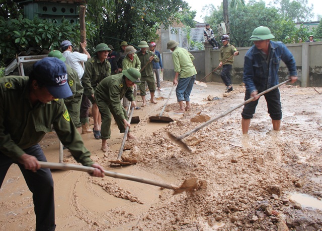 Sạt lở núi, hàng chục hộ dân thấp thỏm lo bị vùi lấp - 6 Công an xã Hưng Yên Nam giúp người dân thu dọn số bùn đất tràn vào trong sân.