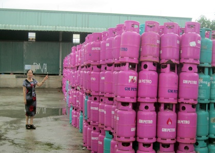 Bà Trần Thị Kim Tân bên những vỏ bình ga của Cty GaMi Gas đã bị bán cho người khác.