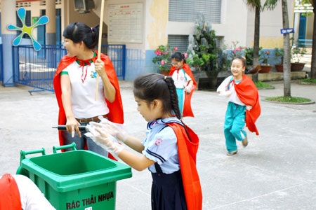 Phương pháp mới giáo dục lối “sống xanh” cho trẻ - 3 Thích thú khoác áo choàng đỏ, các em nhỏ tỏa ra khắp sân trường để đi thu gom rác.